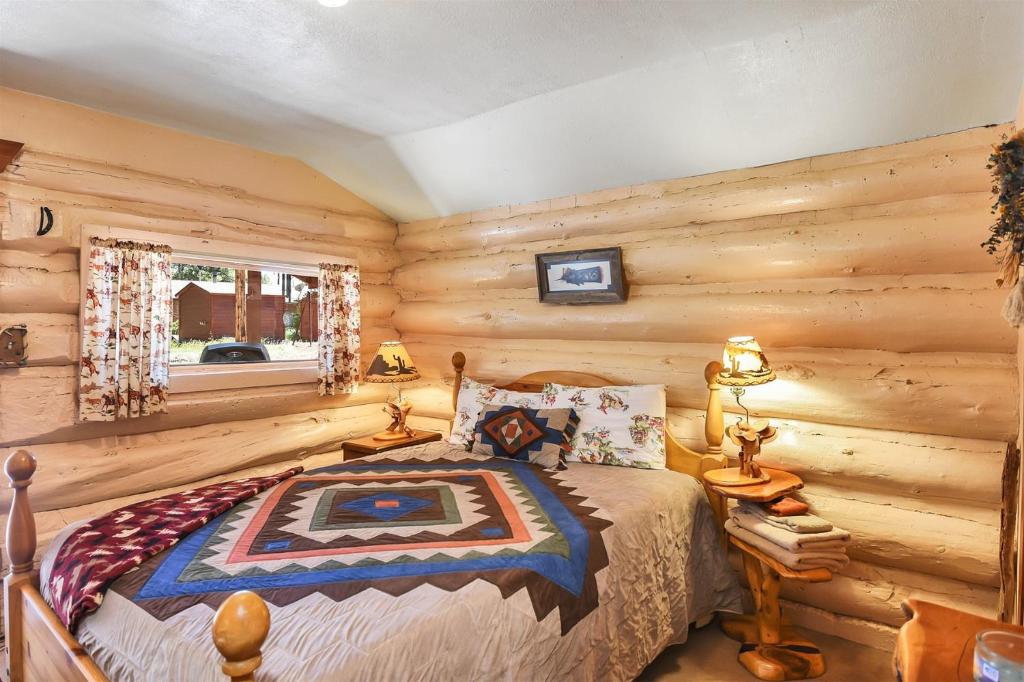 Postel nebo postele na pokoji v ubytování Rogers Cabin Historic Log Cabin in the Woods Near Grand Canyon Flagstaff