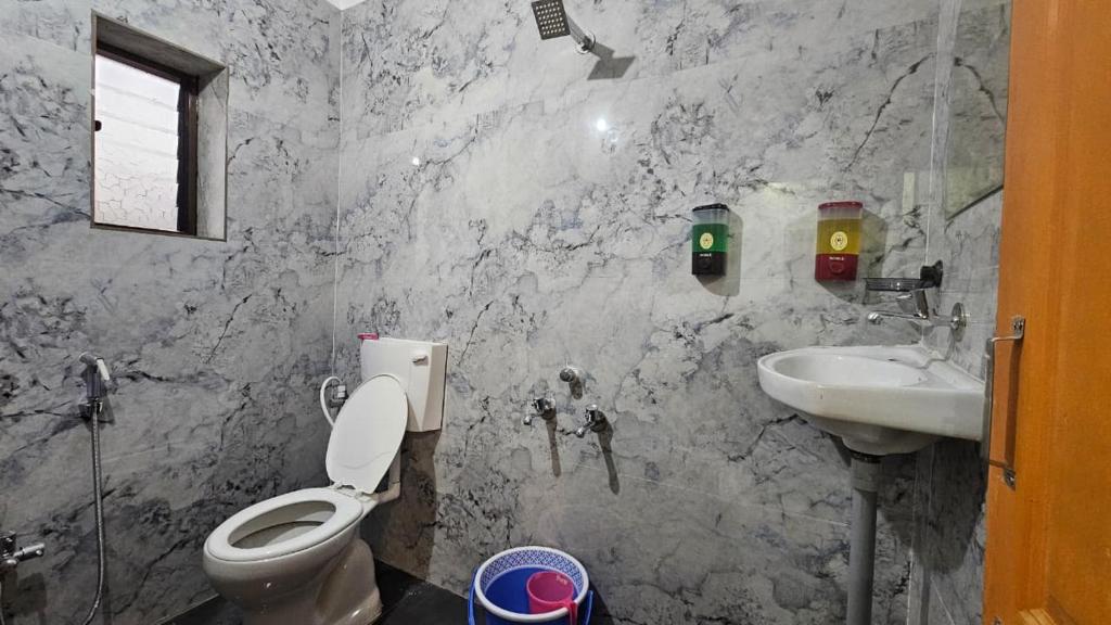 een badkamer met toilet en wastafel bij Hotel Sai Pratham in Shirdi