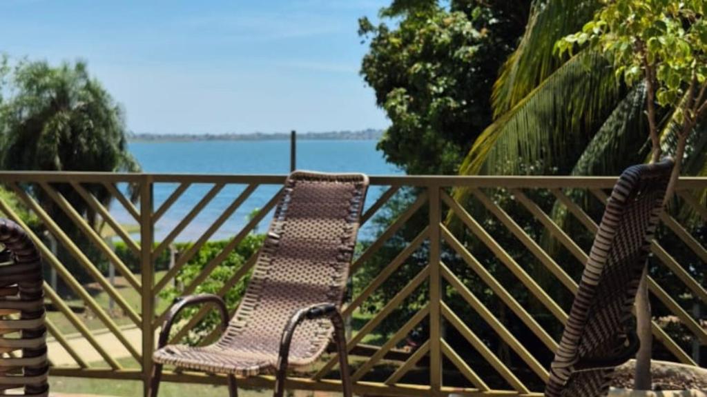 a pair of chairs sitting on a balcony overlooking the water at Rancho com acesso direto ao rio, área verde e lazer completo in Santa Fé do Sul
