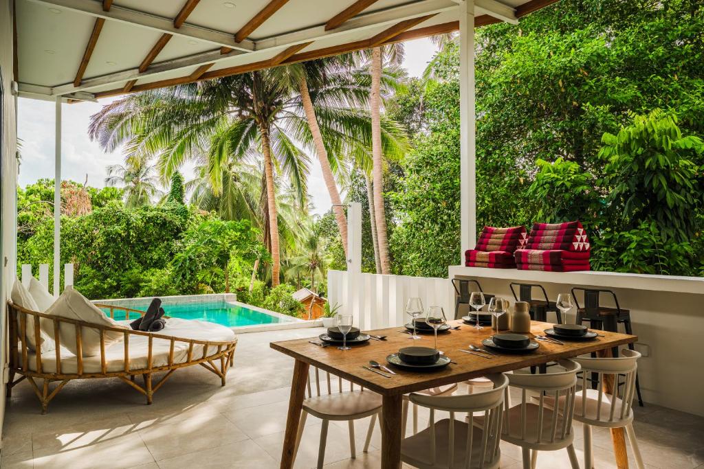 a patio with a table and chairs and a pool at Serene Jungle Escape with Private Pool by Sea N' Rent in Haad Chao Phao