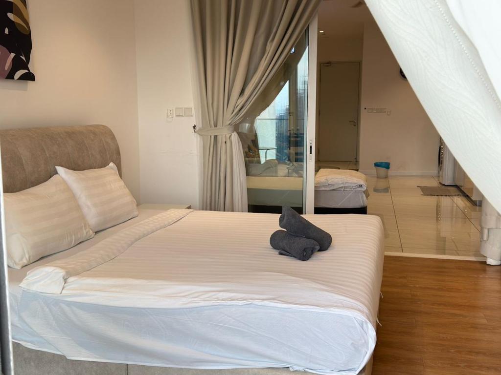 ein Schlafzimmer mit einem Bett mit einem schwarzen Handtuch darauf in der Unterkunft Maju Suites Berjaya Times Square in Gua Sai