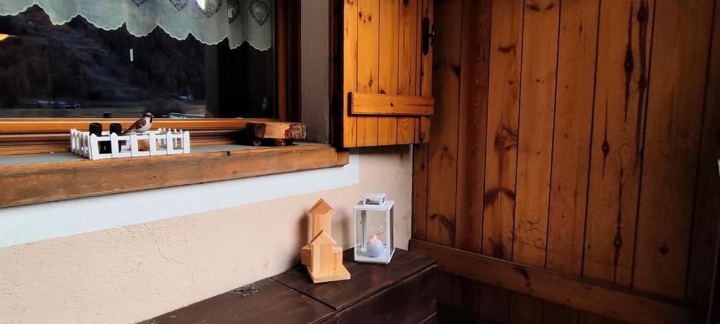 a wooden figurine sitting on a ledge next to a window at Sant'Orso Cozy Home in Cogne