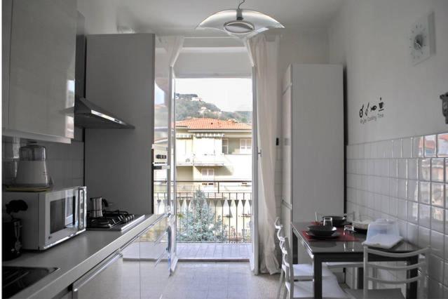 una cocina con una gran puerta abierta a un balcón en Casa Vacanze Luli, en La Spezia