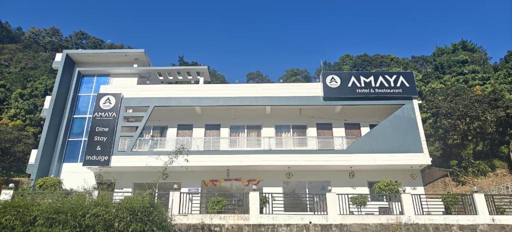 a white building with a sign on top of it at Amaya hotel in Kāthgodām