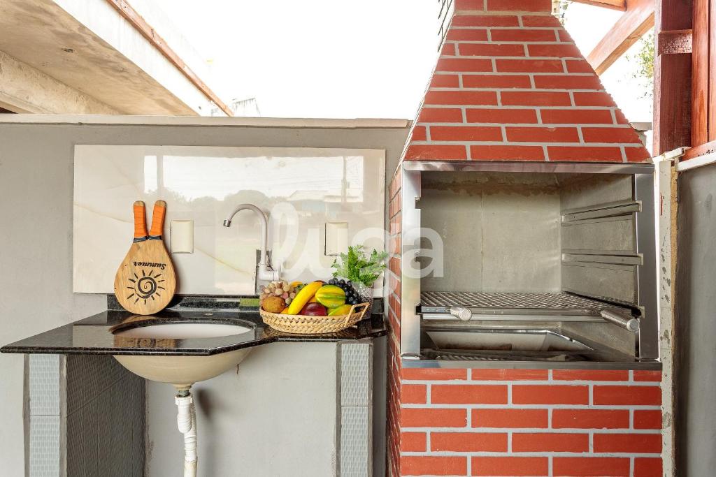 a kitchen with a sink and a brick oven at LUGA: Peaceful Retreat | Lagoon & Imbituba in Imbituba