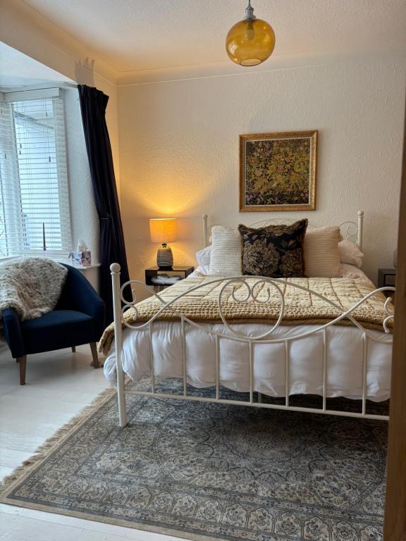 a bedroom with a white bed and a blue chair at Number 78 Guest house M56 junction 12 located 5 minutes drive from Frodsham Continental breakfast Included in Frodsham