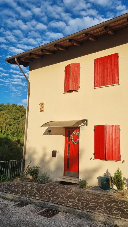 a house with a red door and red windows at Casa Florian in Vito dʼAsio