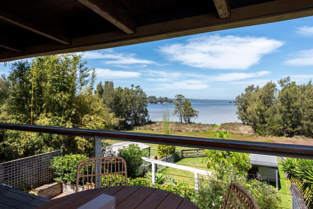 ein Balkon mit Blick aufs Wasser in der Unterkunft Stunning Big Private Waterfront Cottage in Erowal Bay