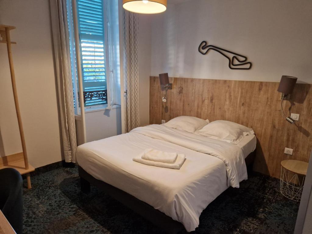 a bedroom with a bed with a towel on it at Cit'hotel Le Phenix Limoges in Limoges