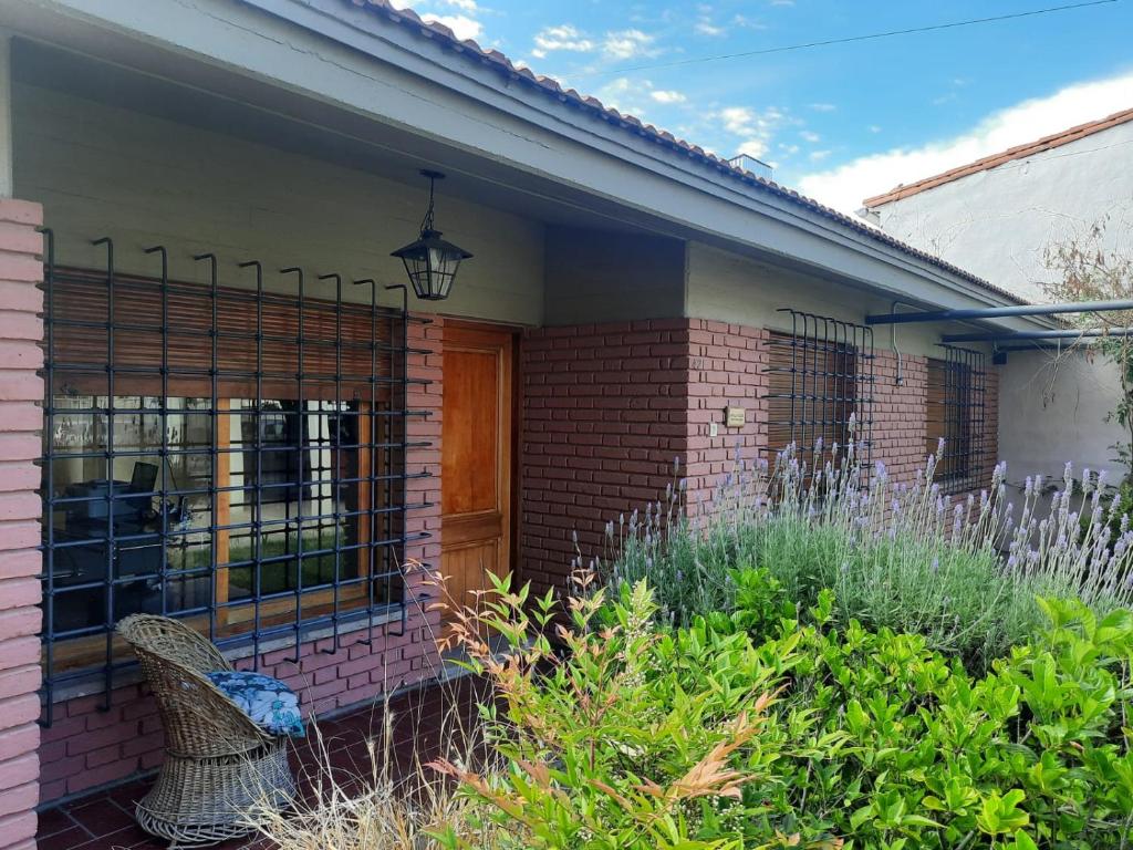 une maison en briques avec un porche et une clôture dans l'établissement La Casa de Ana, à San Rafael