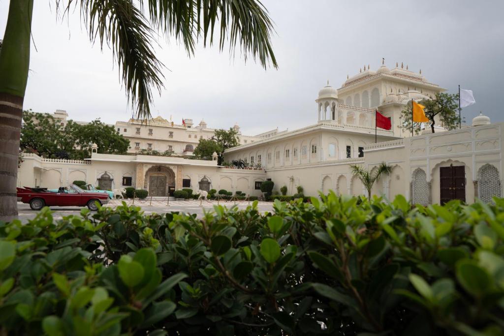 Un edificio con un coche rojo aparcado delante. en The Raj Palace (Small Luxury Hotels of the World), en Jaipur