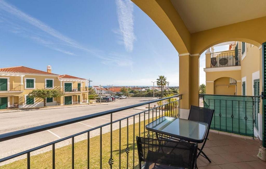 a balcony with a table and chairs and a street at Apartment Karin mit schönen Meerblick in Porches