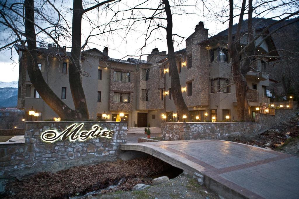 a large building with a bridge in front of it at Melies Boutique Hotel in Kato Loutraki