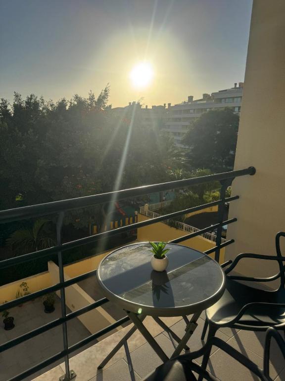 a table and chairs on a balcony with the sunset at Ajuda Mar Holidays in Funchal