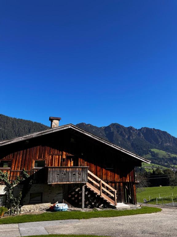 a large wooden barn with mountains in the background at Trail & Tiefschnee Lodge in Reith im Alpbachtal