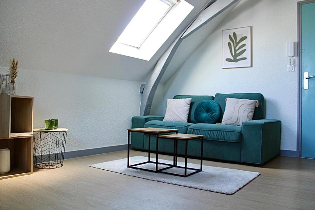 a living room with a blue couch and a table at Apartee - Charmant T2 en centre ville de Laval in Laval