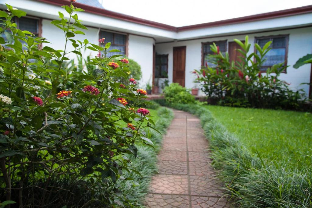 un camino de ladrillo delante de una casa con flores en Casa Kibi Kibi en San José