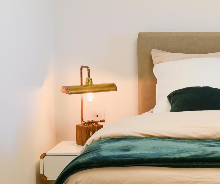 a bedroom with a bed and a lamp on a night stand at chambresdusoleil in Hoffen