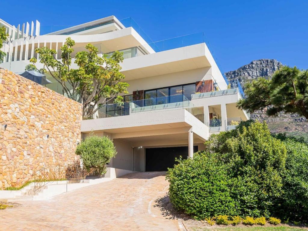 een groot wit huis op de top van een berg bij Marang Villa in Kaapstad