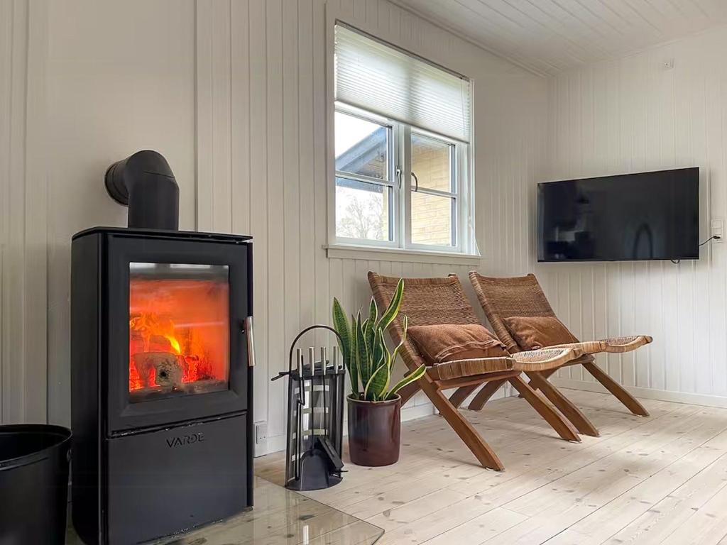 a living room with a fireplace and a couch at Sommerhus Med Sauna Ved Udsholt Strand in Udsholt Sand