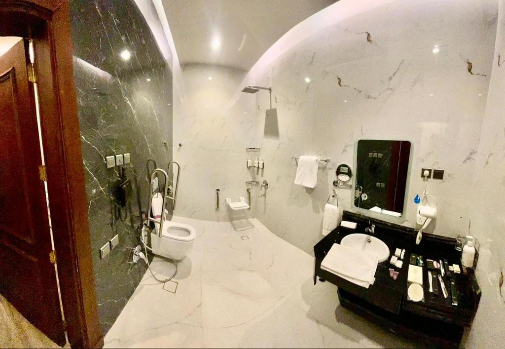 Un baño blanco con lavabo e inodoro. en Tura Hotel AlNuzha- فندق ترى النزهة, en Riad