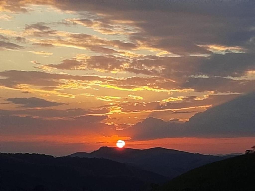 una puesta de sol con la puesta de sol sobre las montañas en Refúgios SUNSET Serra Fluminense, en Areal