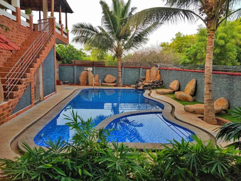a swimming pool in the middle of a yard at Greens Heritage Resort with Swimming Pool in Auroville