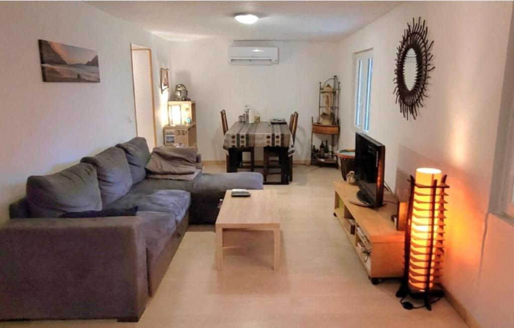 een woonkamer met een bank en een tafel bij grains de soleil in Castelnau-dʼEstrétefonds