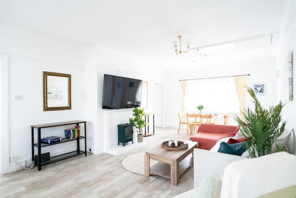ein Wohnzimmer mit Sofa und Tisch in der Unterkunft Coastal 4-Bed Family Retreat in Sandbanks in Sandbanks
