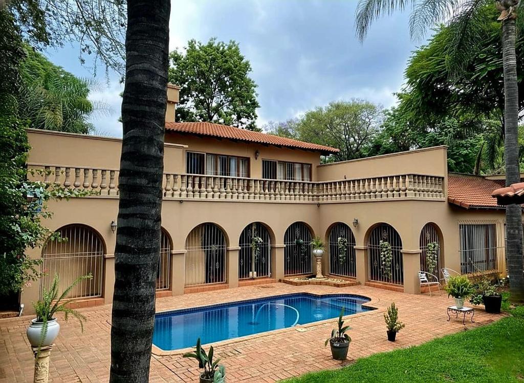 an exterior view of a house with a swimming pool at Kloofyard Guesthouse in Pretoria