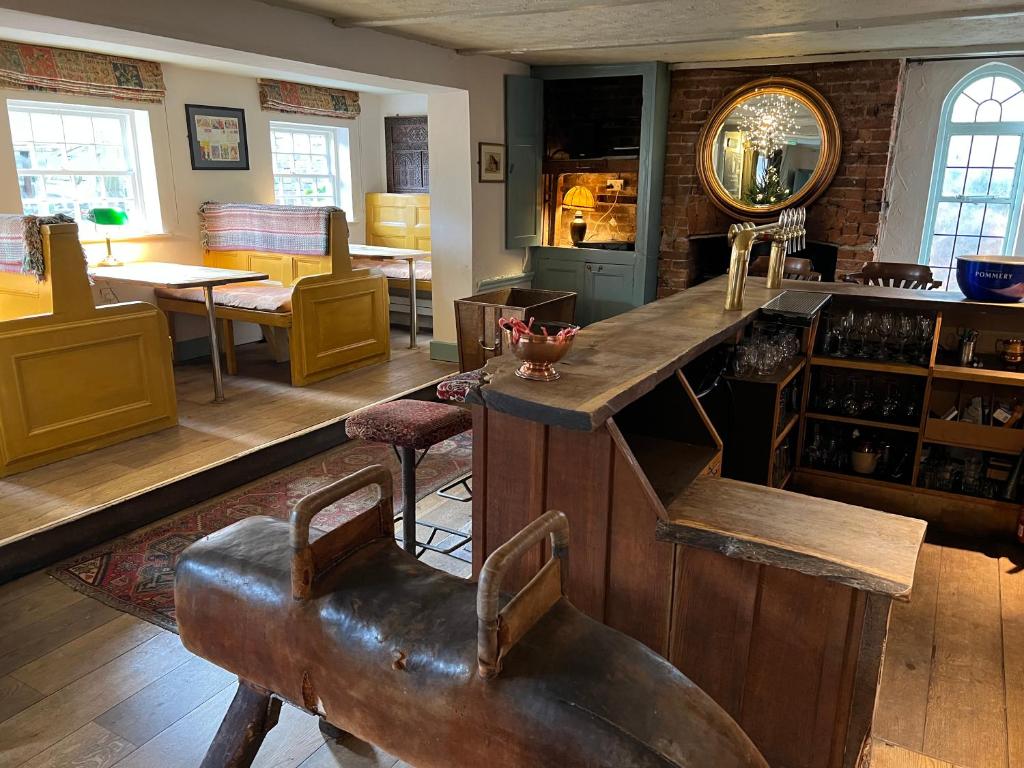 a large room with a bar and a table and chairs at Lamb Inn in Wartling