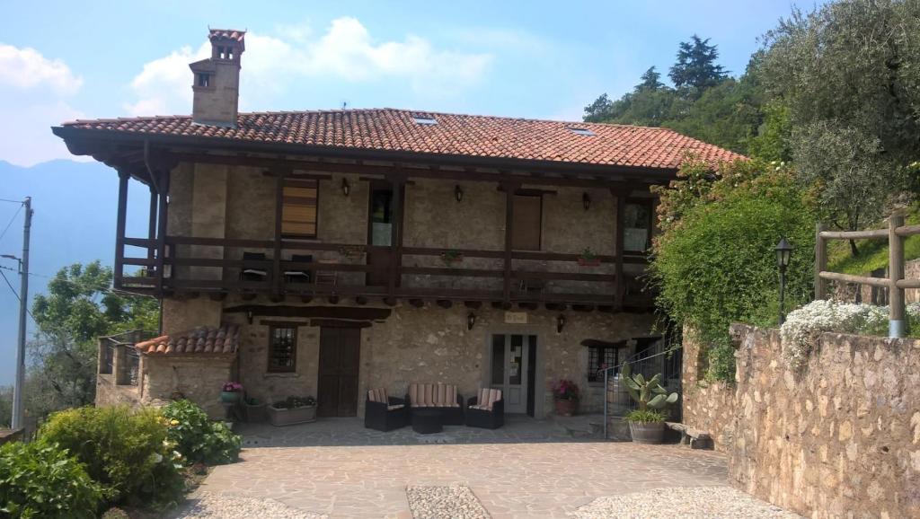马罗内Agriturismo El Giardì的大型石屋设有门廊和阳台