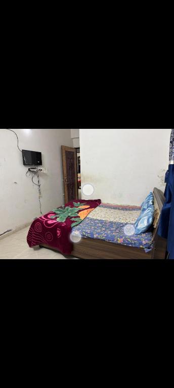 a bedroom with a bed with a blanket on the floor at Gurukrupa Home stay in Rājpīpla