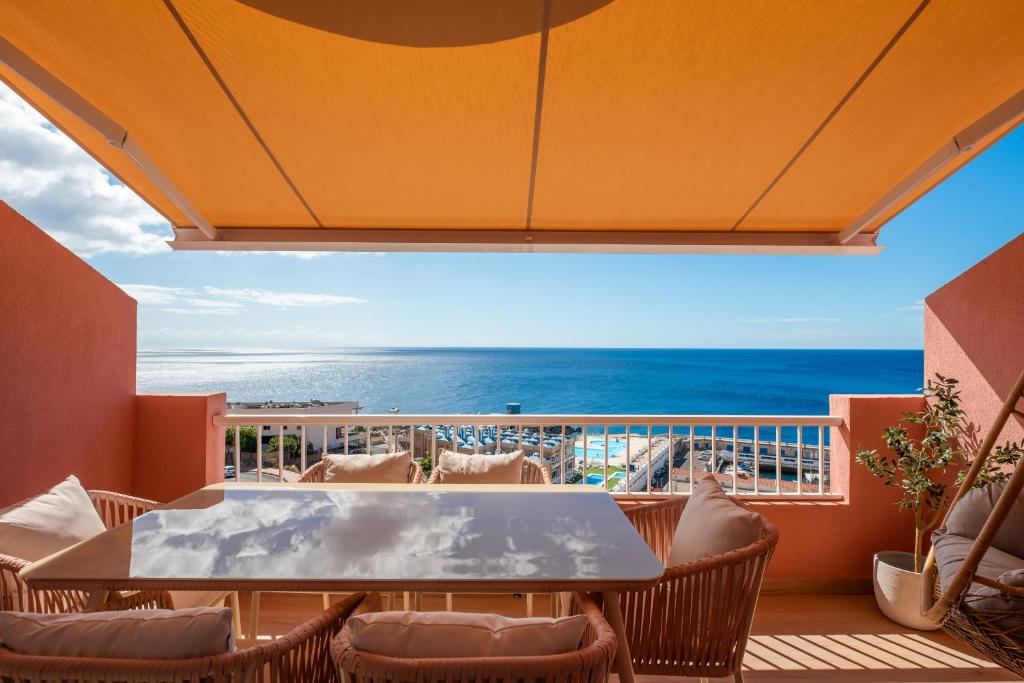 un balcon avec une table et des chaises et l'océan dans l'établissement Dúplex de Lujo Frente al Mar Terraza en Radazul, à Radazul