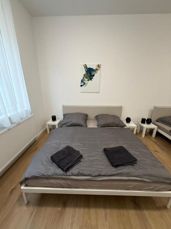 ein großes Bett in einem weißen Zimmer mit 2 Tischen in der Unterkunft The Blue Church Family Apartment Old Town Self Check-in 6 guest in Bratislava