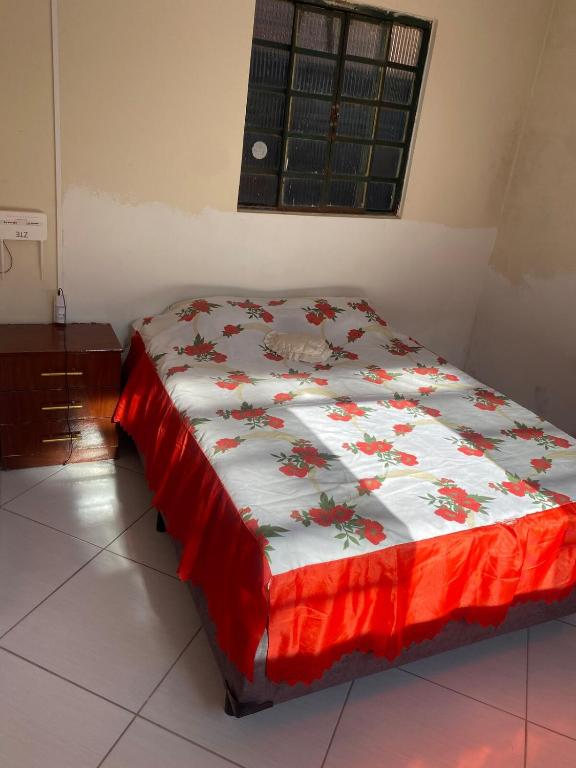 Casa acomoda 2 casal في غواراتينغيتا: غرفة نوم بسرير لحاف احمر وبيض