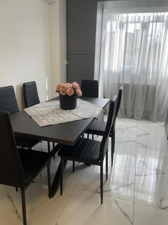 a dining room table and chairs with a plant on it at Apartamentul lui Radu in Caracal
