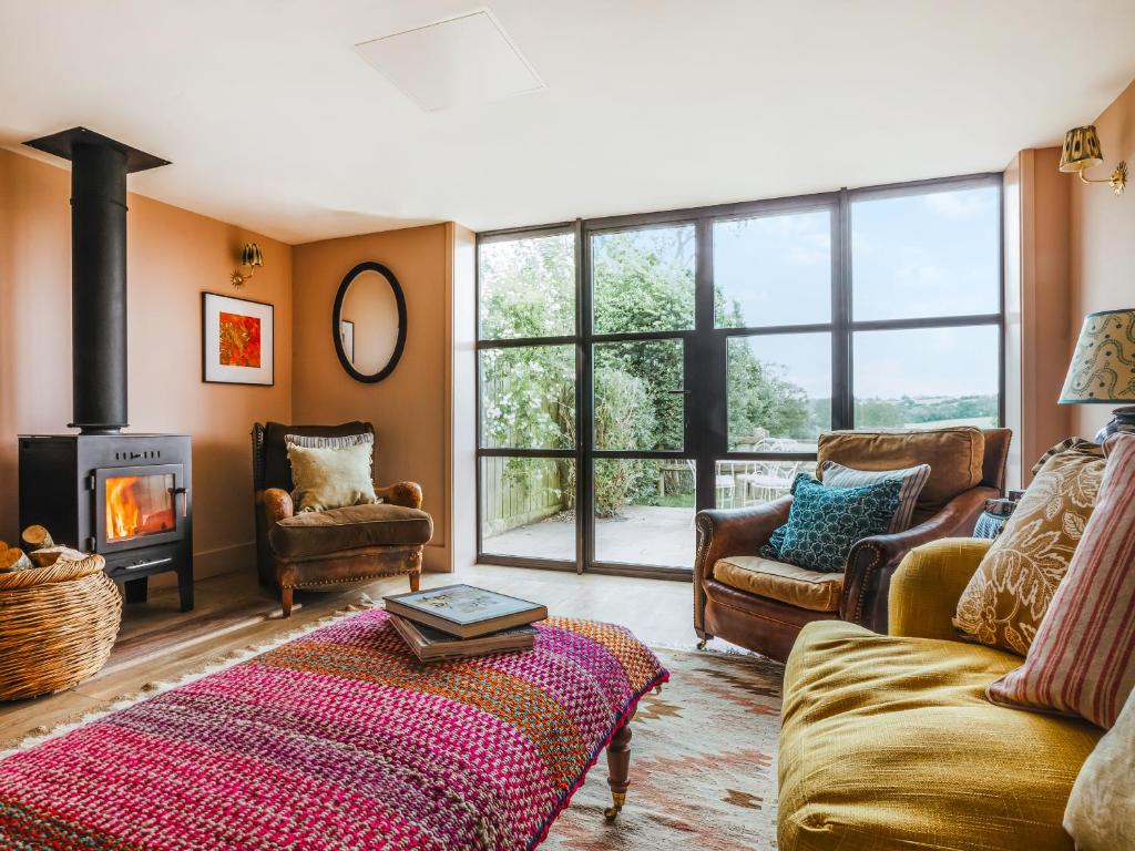 a living room with a couch and a fireplace at The Shearing Shed in Peasmarsh