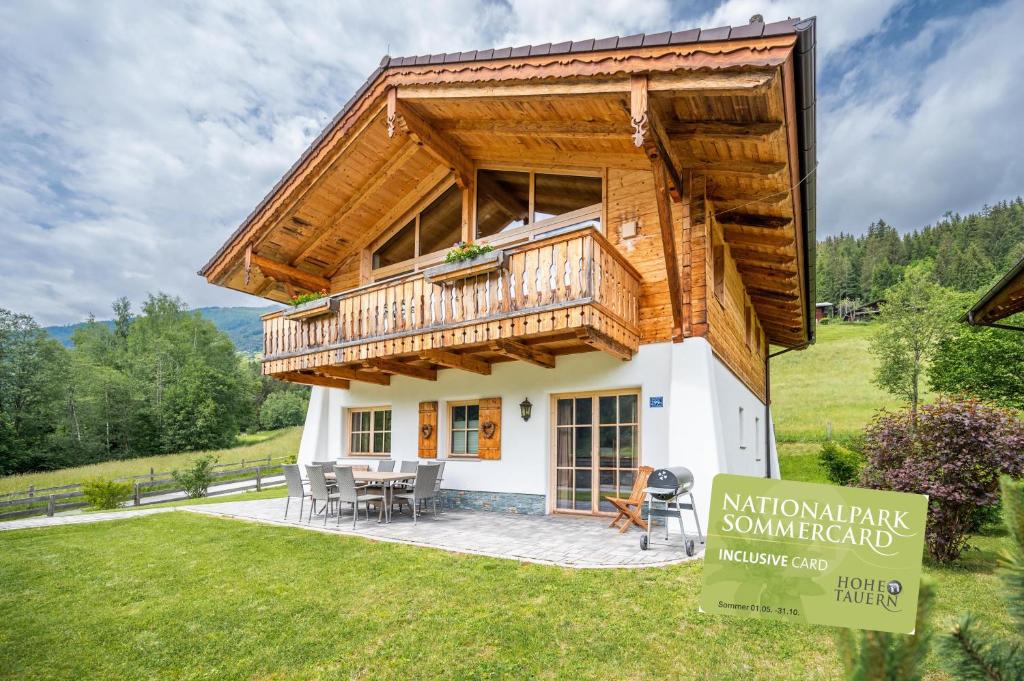 a small house with a wooden roof and a balcony at Chaletdorf am Sonnenhang in Neukirchen am Großvenediger