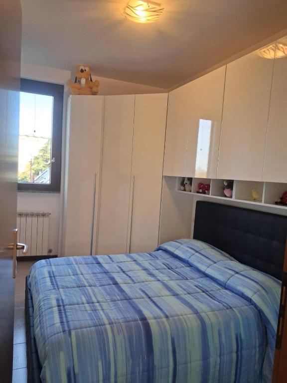 a bedroom with a bed and white cabinets and a window at Bilocale comodamente collegato con centro Milano in Garbagnate Milanese