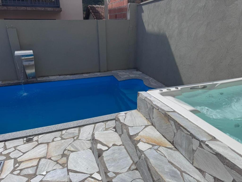 ein Pool neben einem Gebäude in der Unterkunft Casa Férias Xero in Capitólio