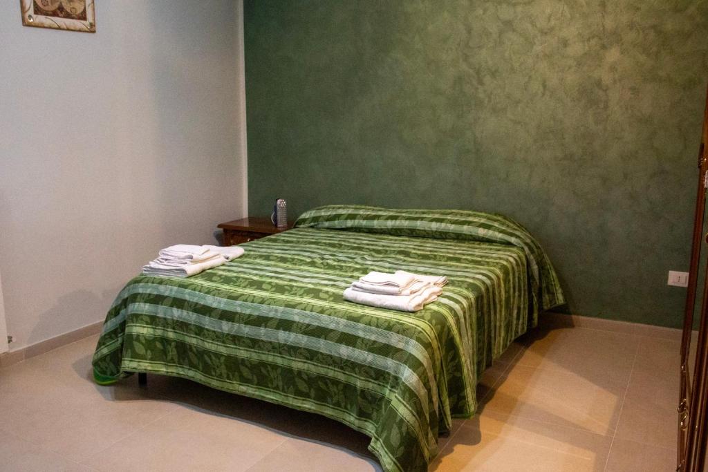 a green bedroom with a bed with towels on it at Casa Vacanze Chimenti in Tarsia
