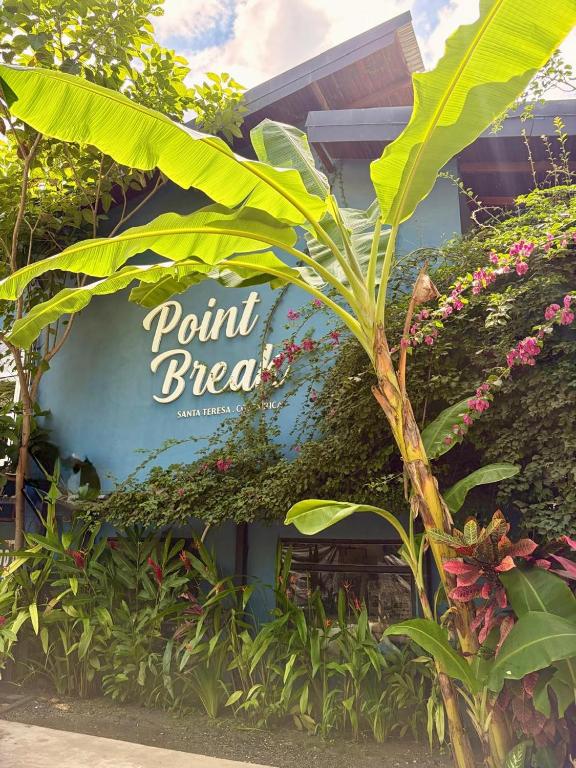 a sign in front of a building with plants at Point Break Santa Teresa in Santa Teresa Beach