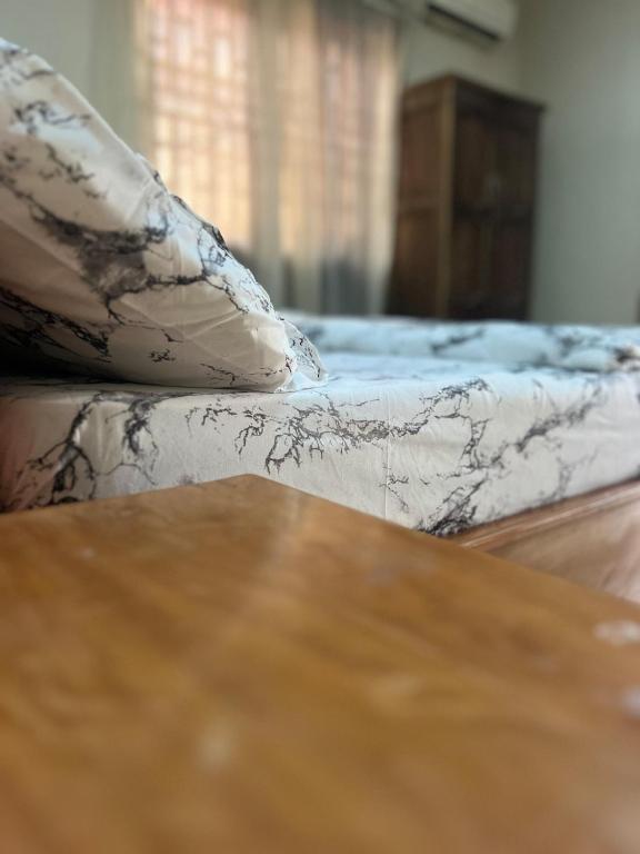 een bank met kussens naast een houten tafel bij Otam Homes in Ondo