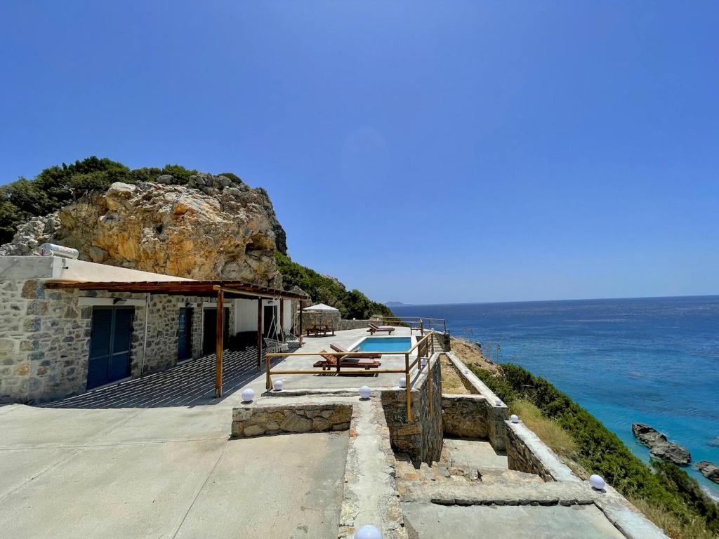a house on a cliff next to the ocean at Ocean Bliss Villa, By Hellocrete in Kerames