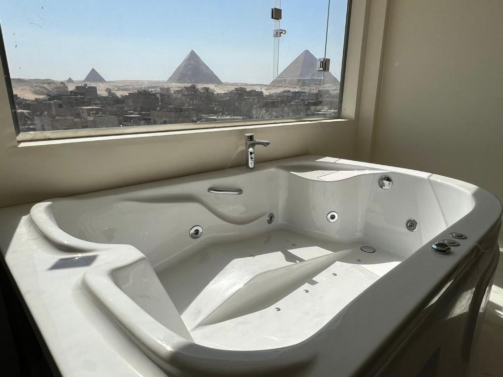 开罗La vista delle piramidi的带窗户的浴室里的浴缸