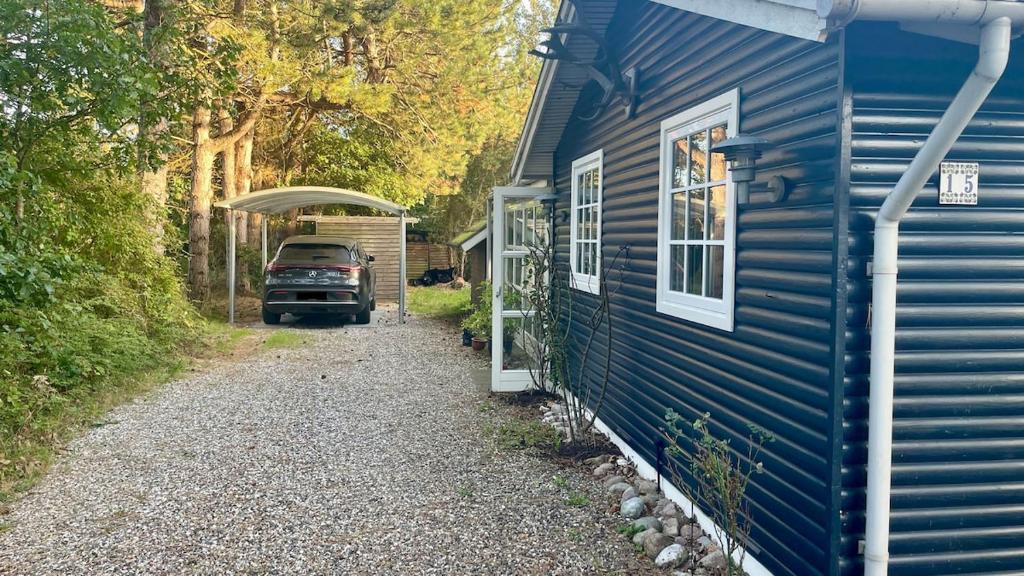 un camion garé à côté d'une maison bleue dans l'établissement Cozy cottage near beach and nature, à Martofte