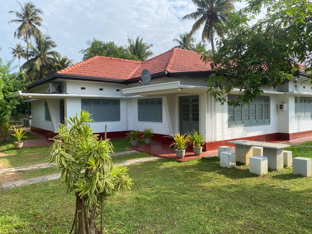 a white house with a yard with a house at Villa 95 Hiriketiya in Dickwella
