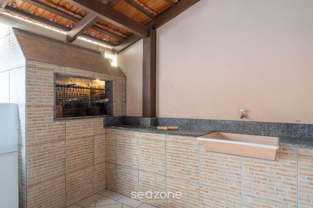 a bathroom with a sink and a brick wall at Casa a 4 min a pé da praia em Porto Belo BRR0097 in Perequê