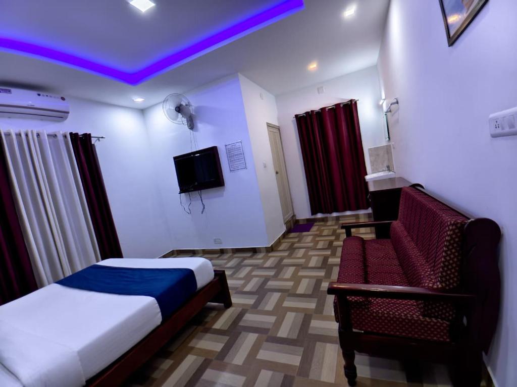 卡尔佩特塔Deluxe Residency的一间酒店房间，里面有一张床和一把椅子